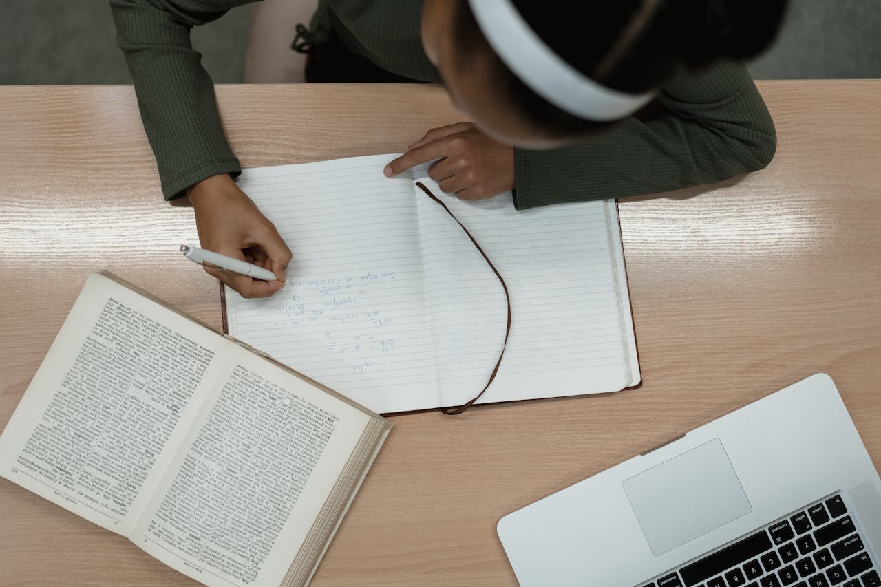 A person takes notes in a notebook, emphasizing study and learning. Ideal for educational themes.